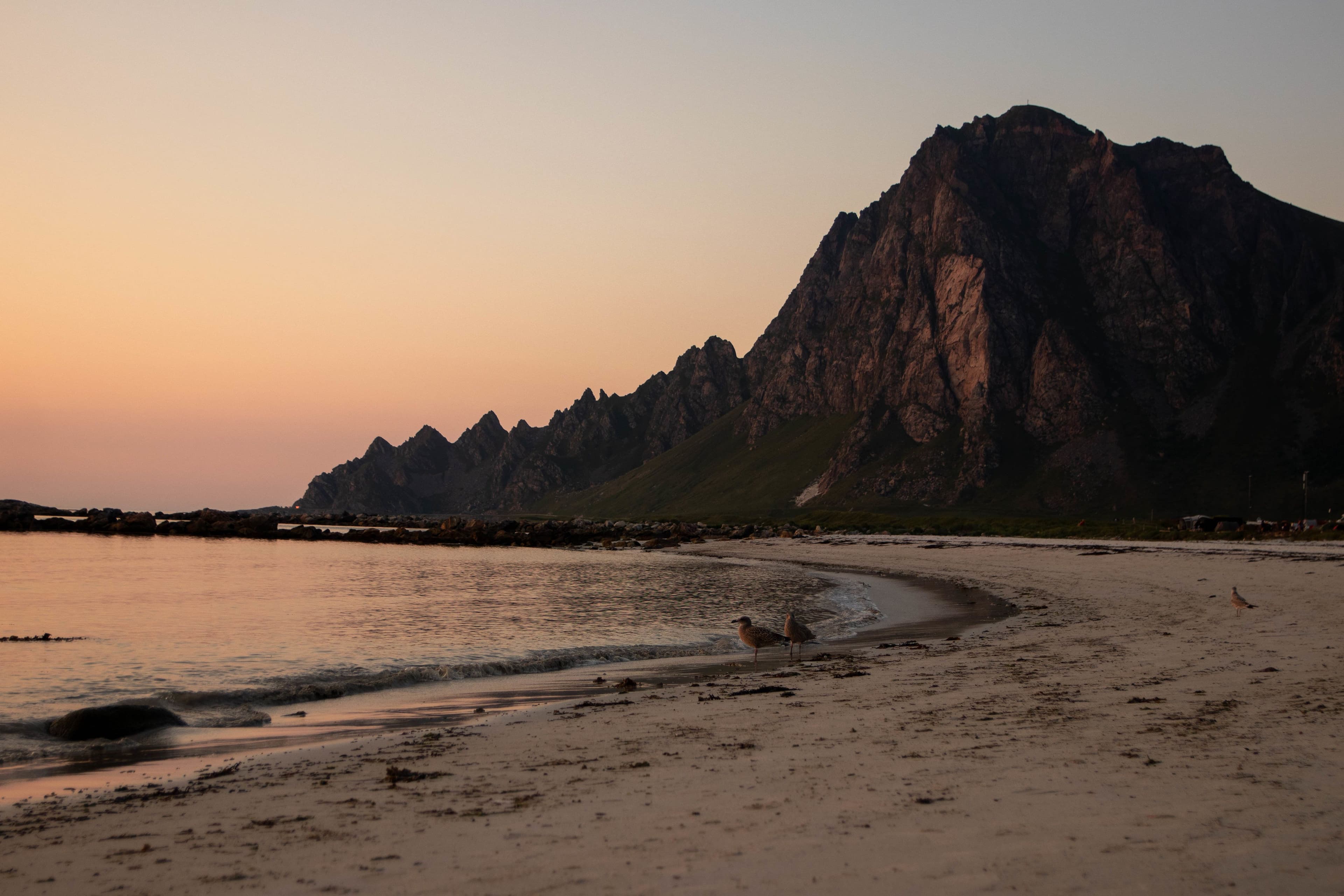 Strand og fjell i solnedgang